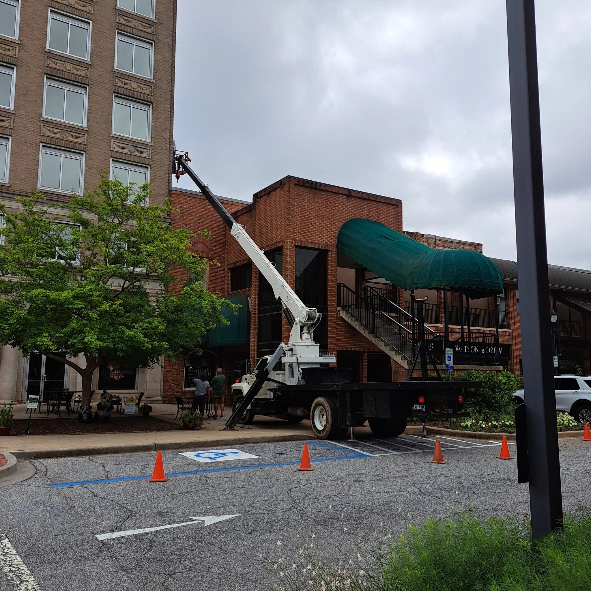 Boom truck crane lifting heavy materials to the upper stories of a building