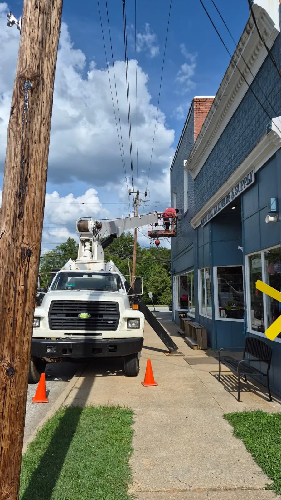 Boom truck lifting a tall sign and pole into position
